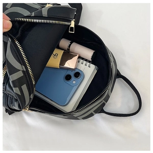 Internal view of black leather backpack showing space for phone and cosmetics