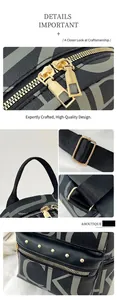 Detail of black leather backpack with grey logo prints, gold hardware and rivet accents