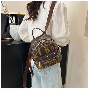 Detail of trendy brown monogram backpack with gold studs and smooth zipper closure