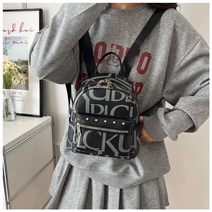Detailed close-up of retro letter print mini backpack with golden studs and metal zippers