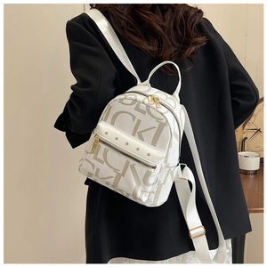 Detail of white PU leather mini backpack with brown letter prints and gold rivets
