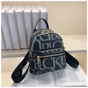 Detail of black pebbled leather backpack with letter print and gold rivet hardware