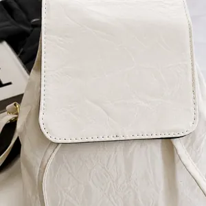 Close-up of white PU leather backpack featuring natural wrinkled texture and neat stitching
