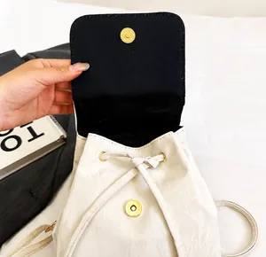 Detail of the high-quality magnetic snap closure and drawstring on white backpack