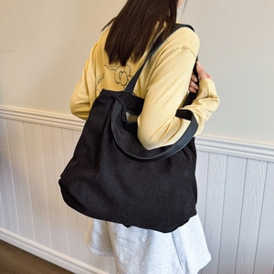 Large black corduroy tote bag for women with leather straps in a casual minimalist style