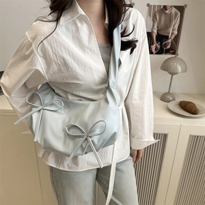 Light blue crescent shoulder bag with pleated straps and cute double bow accents