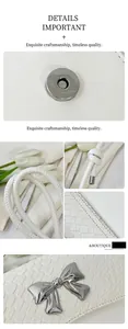 Detail of white crocodile embossed leather bag with silver metal bow and magnetic closure
