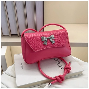 Detail of rose pink handbag featuring woven flap, silver bow buckle, and knotted leather strap