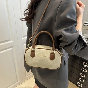 Vintage canvas Boston bag with leather trim and gold fashion logo shown crossbody style