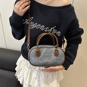 Blue denim mini Boston pillow bag with brown leather handles and adjustable shoulder strap