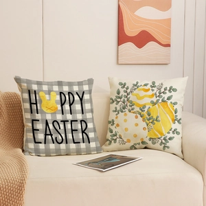 Set of two Easter bunny and egg print throw pillow covers on a cozy sofa setting