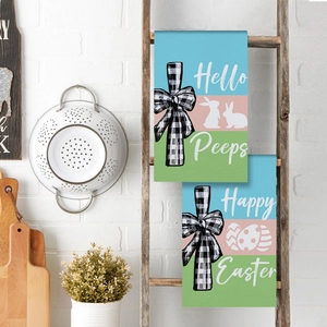 Detailed view of two Easter kitchen towels with bunny prints hanging on a wooden ladder