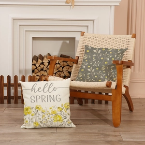 Grey floral print pillow covers set with Hello Spring text on a rustic wooden chair