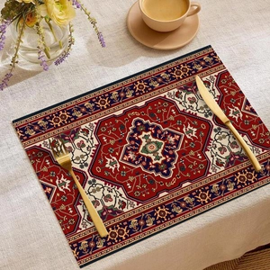 Detailed view of bohemian linen placemat with Persian carpet pattern and golden cutlery