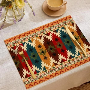 Detail of bohemian linen placemat with geometric patterns on a dining table with cutlery