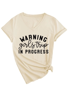 Détail du t-shirt beige col V avec imprimé textuel et nœud élégant sur le devant