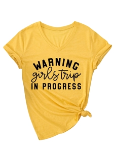 Détail du t-shirt jaune col V avec imprimé Warning Girls Trip et nœud sur l'ourlet