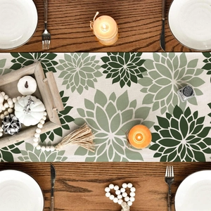 Detail of floral table runner with green leaf pattern on a dark wood dining table