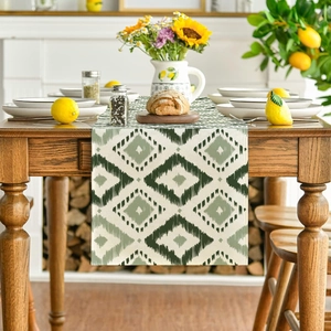 Geometric diamond pattern table runner in dark green and cream on a wooden dining table