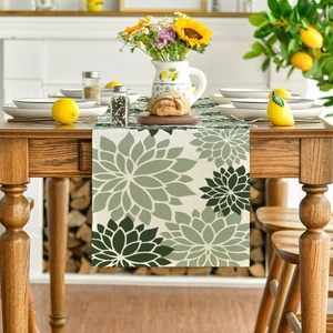 Detail of floral table runner with green dahlia print on dark wood dining table