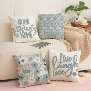 Detailed view of linen cushion covers with floral prints and artistic typography on sofa