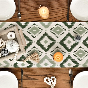 Green and white geometric ikat table runner on a wooden dining table with decor