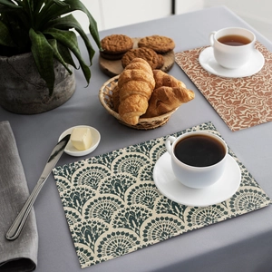 Detailed close-up of bohemian linen placemats with peacock and floral print patterns