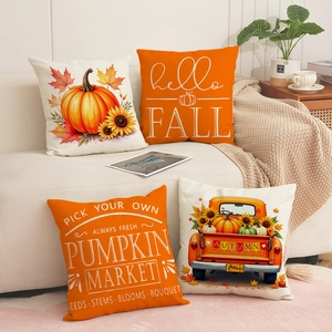 Detail of four autumn pumpkin pillow covers on a sofa with cozy farmhouse decor