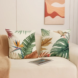 Housses de coussin en lin tropical avec feuilles de monstera et colibri sur canapé
