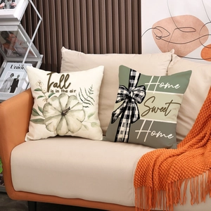 Fall themed pumpkin pillow covers with linen texture on a cozy autumn living room sofa