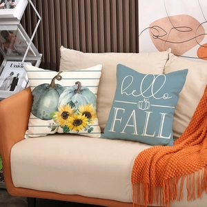 Set di federe autunnali in lino con zucche e girasoli su un divano color beige