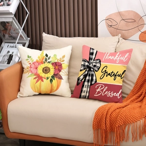 Harvest festival pumpkin throw pillow covers with thankful grateful lettering on a sofa