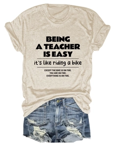 Flat lay of teacher quote t-shirt with distressed denim shorts on white background