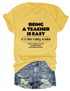 Detail of yellow teacher slogan t-shirt with rolled sleeves and denim shorts