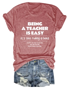Flat lay of rust red teacher quote t-shirt paired with distressed denim shorts