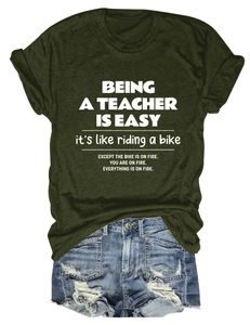 Detail of olive green t-shirt with teacher slogan and distressed denim shorts