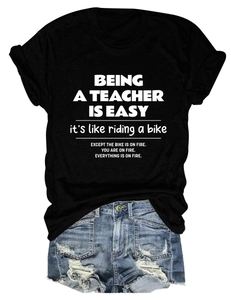 Detail of black cotton T-shirt with teacher quote print paired with denim shorts