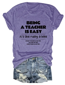 Detail of purple cotton T-shirt with teacher quote paired with blue denim shorts