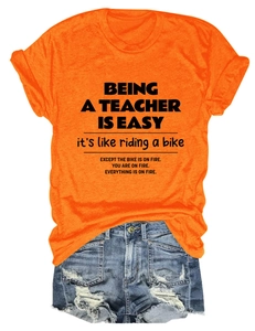 Detail of bright orange cotton T-shirt with black slogan paired with ripped denim shorts