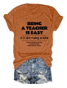 Flat lay of teacher slogan t-shirt paired with distressed denim shorts and sneakers