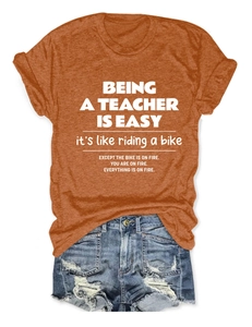 Flat lay of caramel crew neck tee with humorous teacher quote and ripped denim shorts