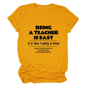 Close-up of ginger yellow crew neck teacher themed T-shirt with black printed text