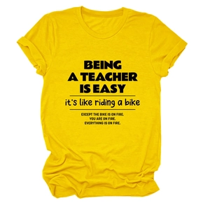 Flat lay of yellow cotton teacher t-shirt with funny quote and rolled cuffs detail