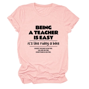 Detail of pink cotton teacher t-shirt showing rolled sleeves and quote print design