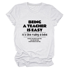 Close-up of white crewneck teacher t-shirt showing black funny slogan text details