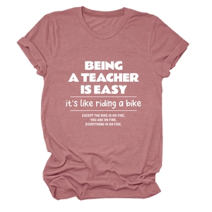 Detail of the soft cotton fabric and white graphic text on a mauve teacher t-shirt
