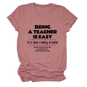 Close-up of funny teacher quote on soft pink cotton t-shirt with folded cuff sleeves