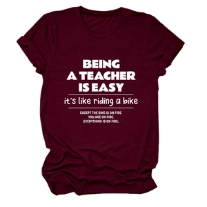 Detail of burgundy teacher slogan t-shirt with white screen-printed lettering texture