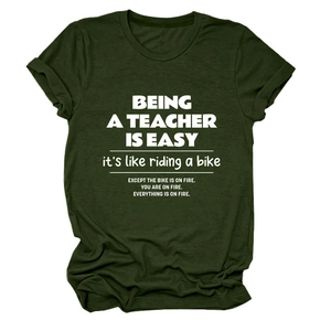 Detail view of dark green crew neck T-shirt with white teacher quote print and rolled sleeves