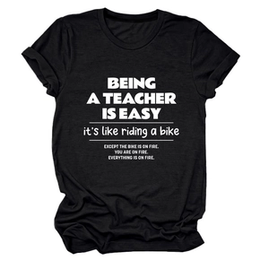 Flat lay of black cotton teacher t-shirt featuring a funny white slogan print design